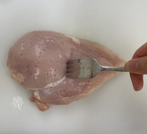 鶏肉はフォークで数か所刺し、穴をあける。裏面も同様に刺す。