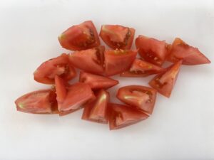 トマトは8等分のくし形にし、さらに半分に切る。